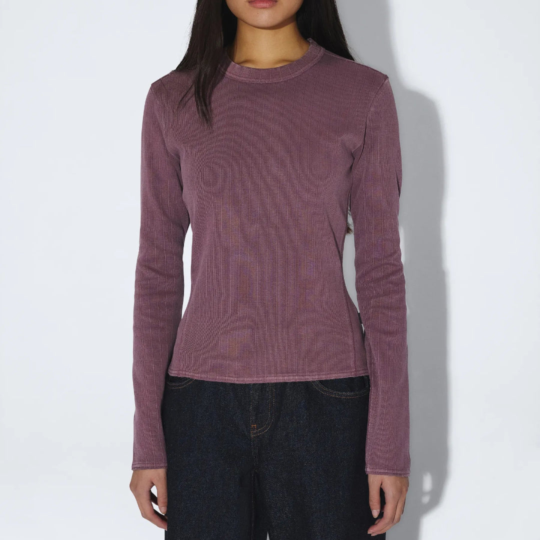 Person wearing a purple long-sleeve shirt against a white background