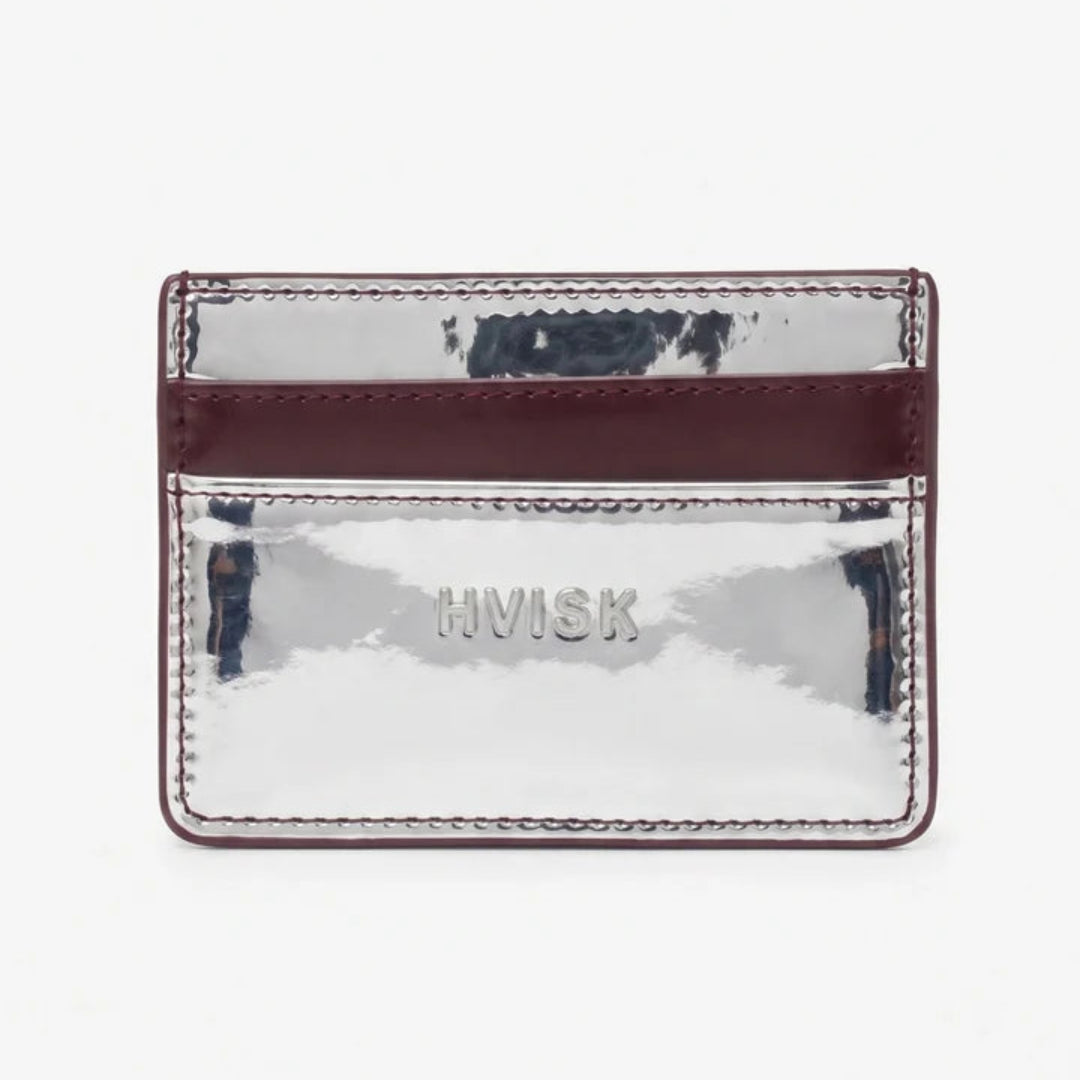 A small metallic silver card holder with a burgundy leather band, featuring the brand name 'HVISK' debossed on the front, set against a plain white background.